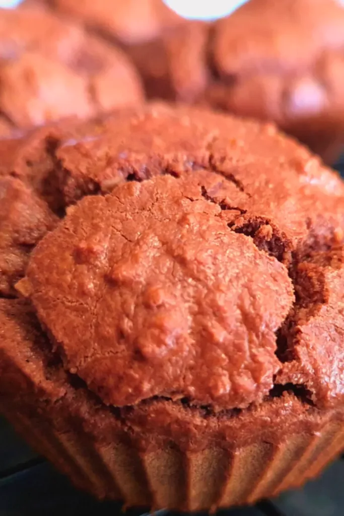 Close up of freshly baked keto chocolate muffins on a wire cooling rack.