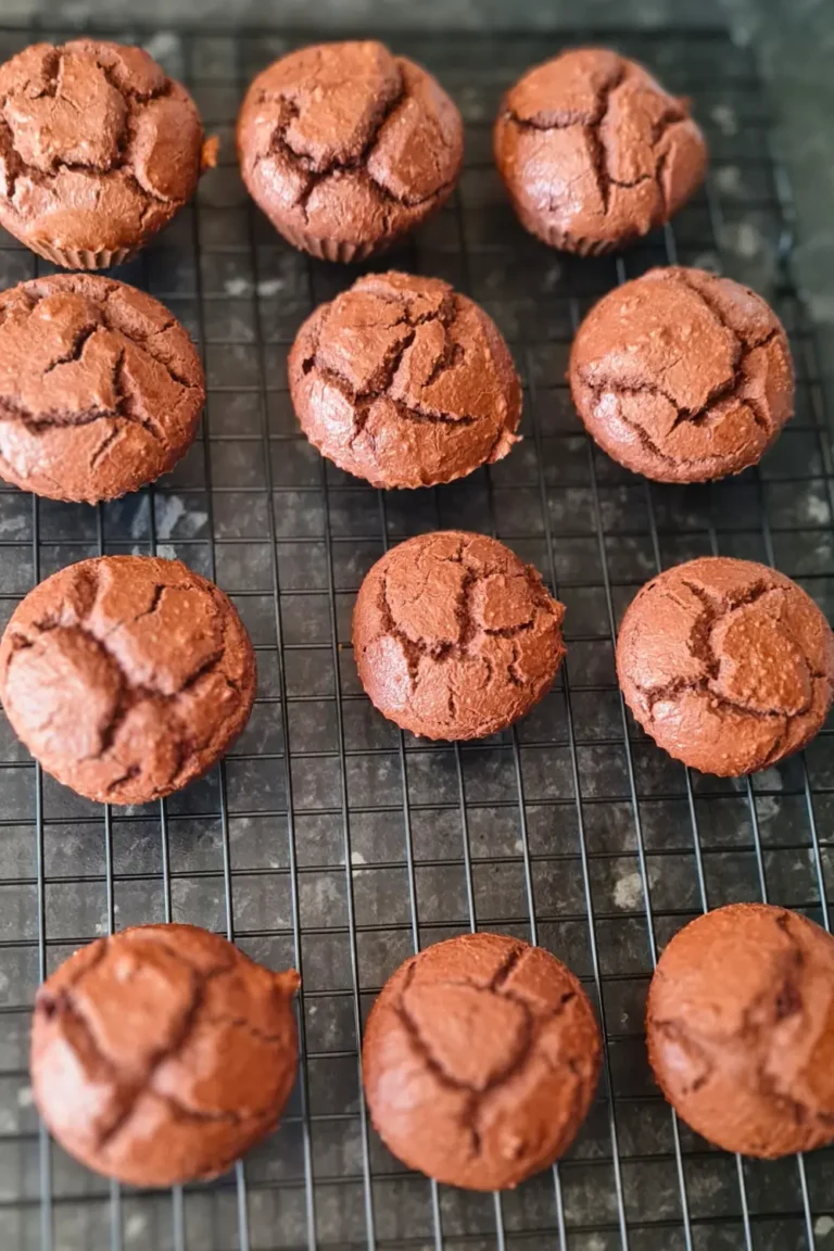 Close up of freshly baked keto chocolate muffins on a wire cooling rack.