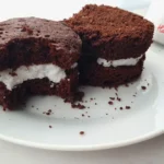 A delicious Keto Oreo Mug Cake with a rich, chocolatey flavor and creamy filling, served on a white plate beside a mug with ‘Have A Mug Cake’ written on it.