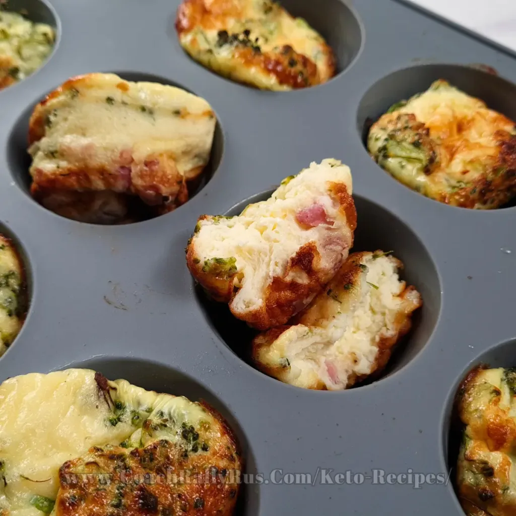 A tray of freshly baked cottage cheese egg muffins with pancetta, showing the golden-brown tops and visible bits of green herbs.
