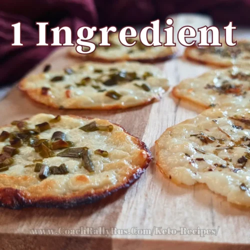 Golden-brown cottage cheese chips seasoned with green herbs, presented on a rustic wooden surface, highlighting the simplicity of the one-ingredient recipe from CoachRallyRus.com’s keto collection.