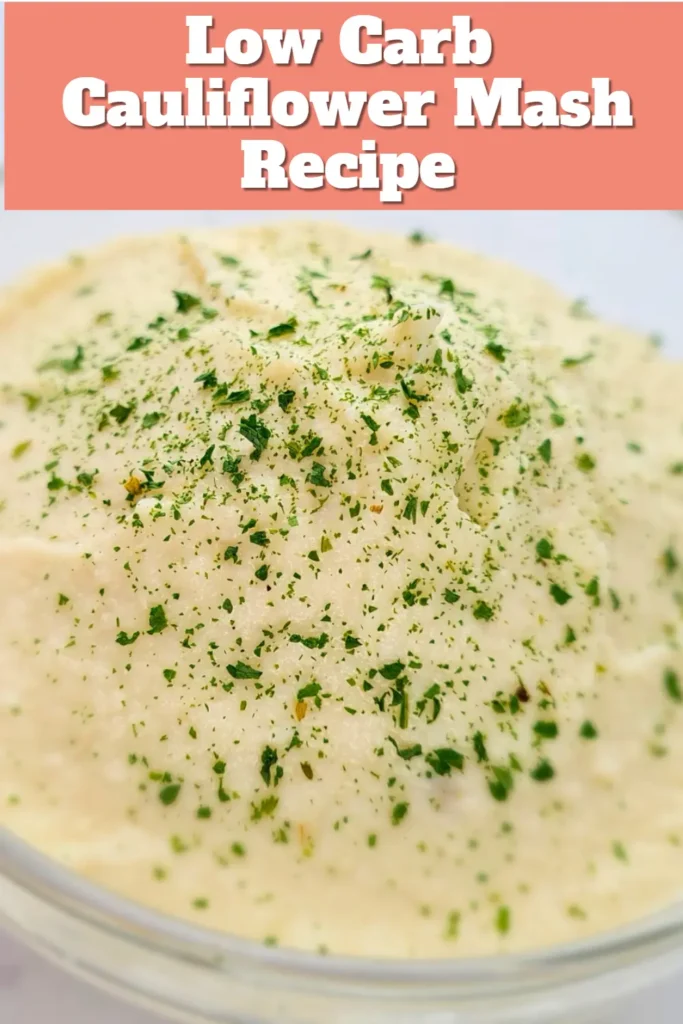 A bowl of creamy Keto Cauliflower Mash topped with finely chopped green herbs, presented against a soft-focus background with the text ‘Low Carb Cauliflower Mash Recipe’ at the top.