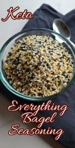 A clear glass bowl filled with Everything Bagel Seasoning on a dark surface.
