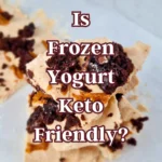 A close-up image of broken pieces of frozen yogurt bark with dark chocolate chunks on a light surface, with the text “Is Frozen Yogurt Keto Friendly?” in bold white and pink letters.