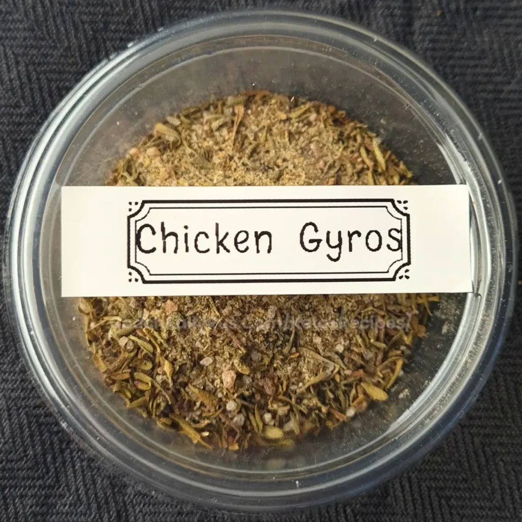 A clear plastic container filled with a blend of dried herbs and spices labeled “Chicken Gyros.”