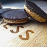Homemade keto peanut butter cups on a wooden surface.