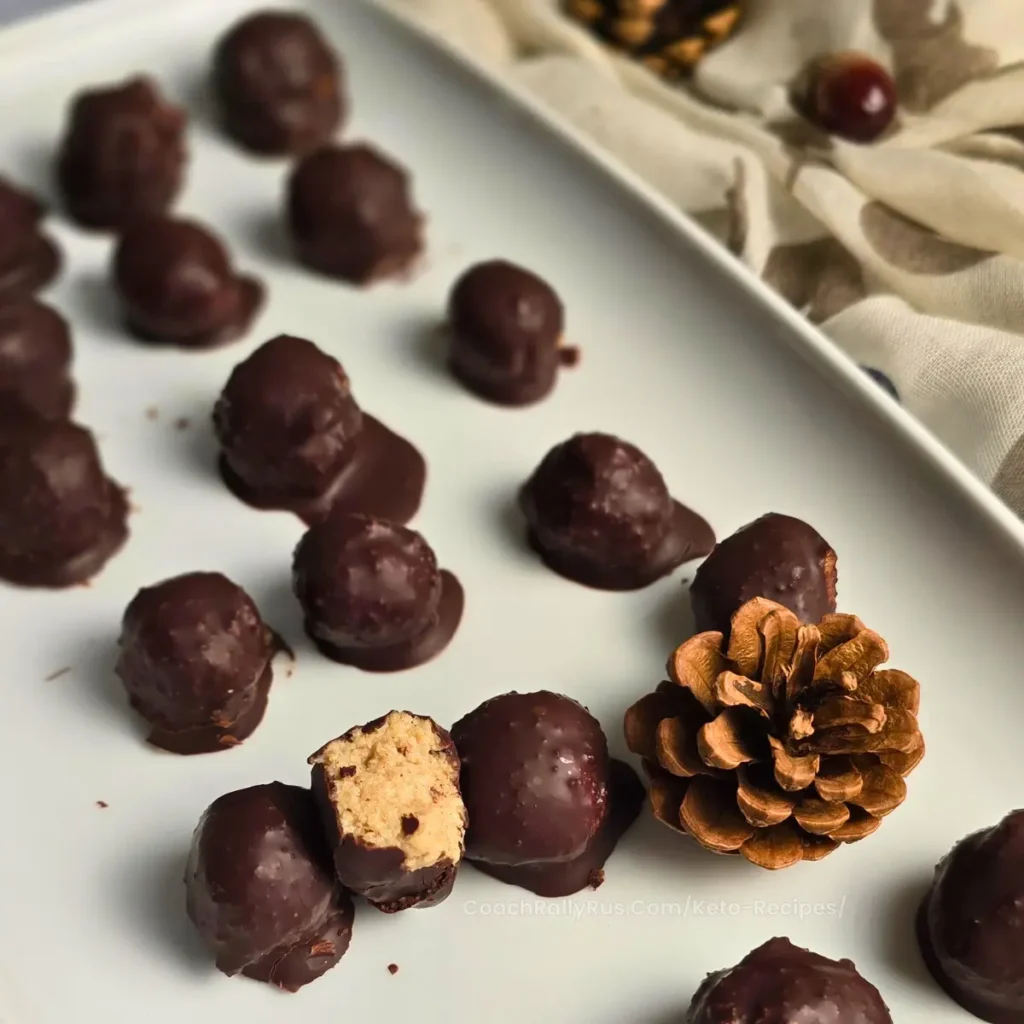 Keto-friendly gingerbread cottage cheese bonbons on a white plate, coated with sugar-free chocolate.