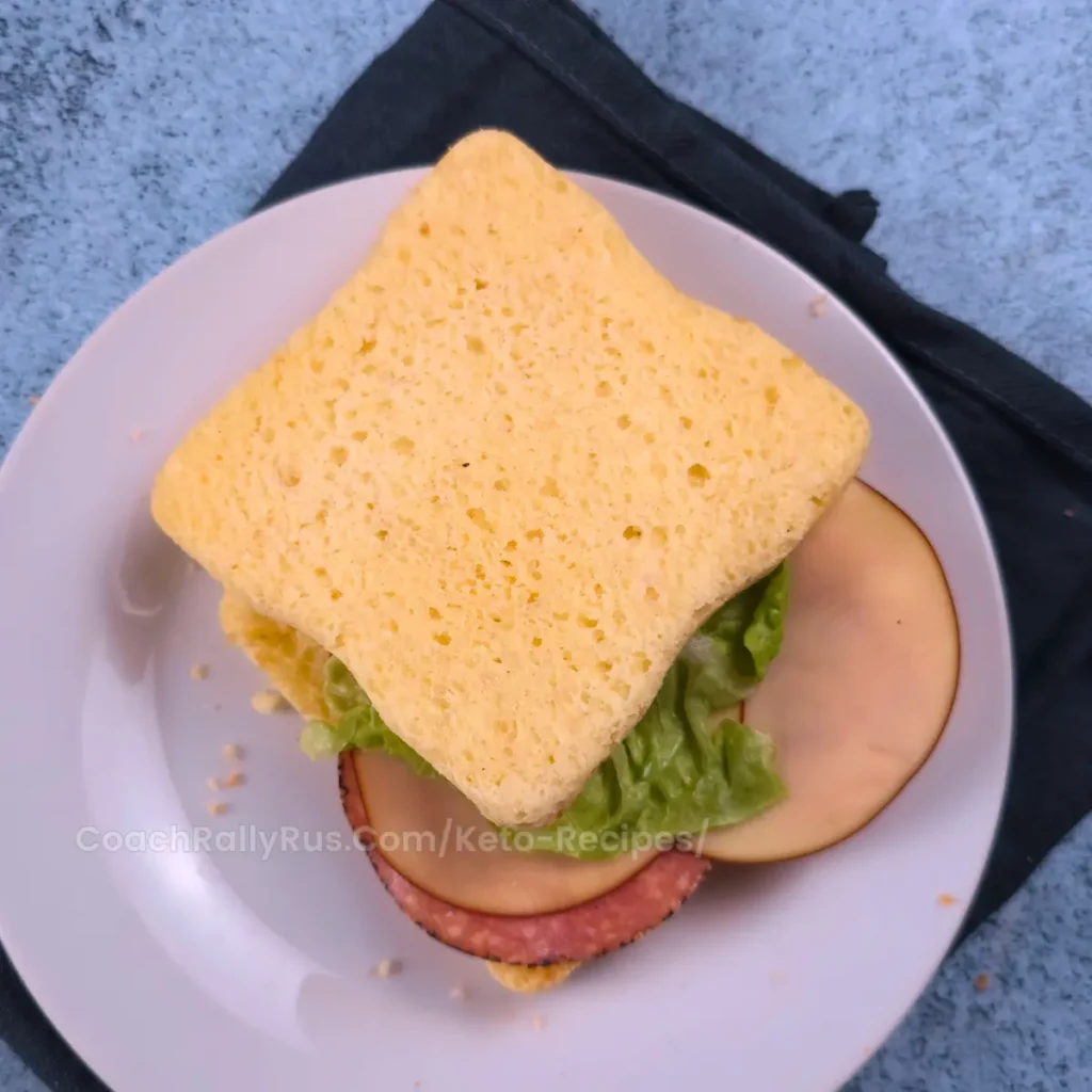 Keto cottage cheese mug bread sandwich with lettuce, cheese, and salami.