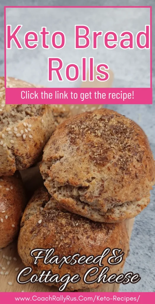 Keto flaxseed cottage cheese bread rolls stacked on a wooden board, topped with sesame and flaxseed.