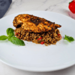 One Skillet Keto Mediterranean Chicken Dinner served over cauliflower and broccoli rice, garnished with basil and parsley.