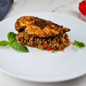 One Skillet Keto Mediterranean Chicken Dinner served over cauliflower and broccoli rice, garnished with basil and parsley.