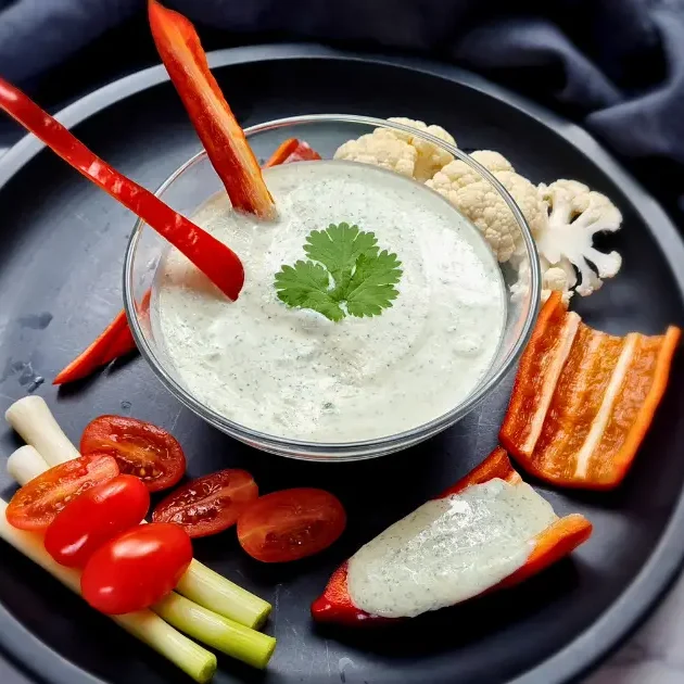 A creamy and inviting bowl of Keto Ranch Dip with Cottage Cheese, garnished with fresh herbs, ready to be enjoyed with a colorful selection of vegetable sticks.