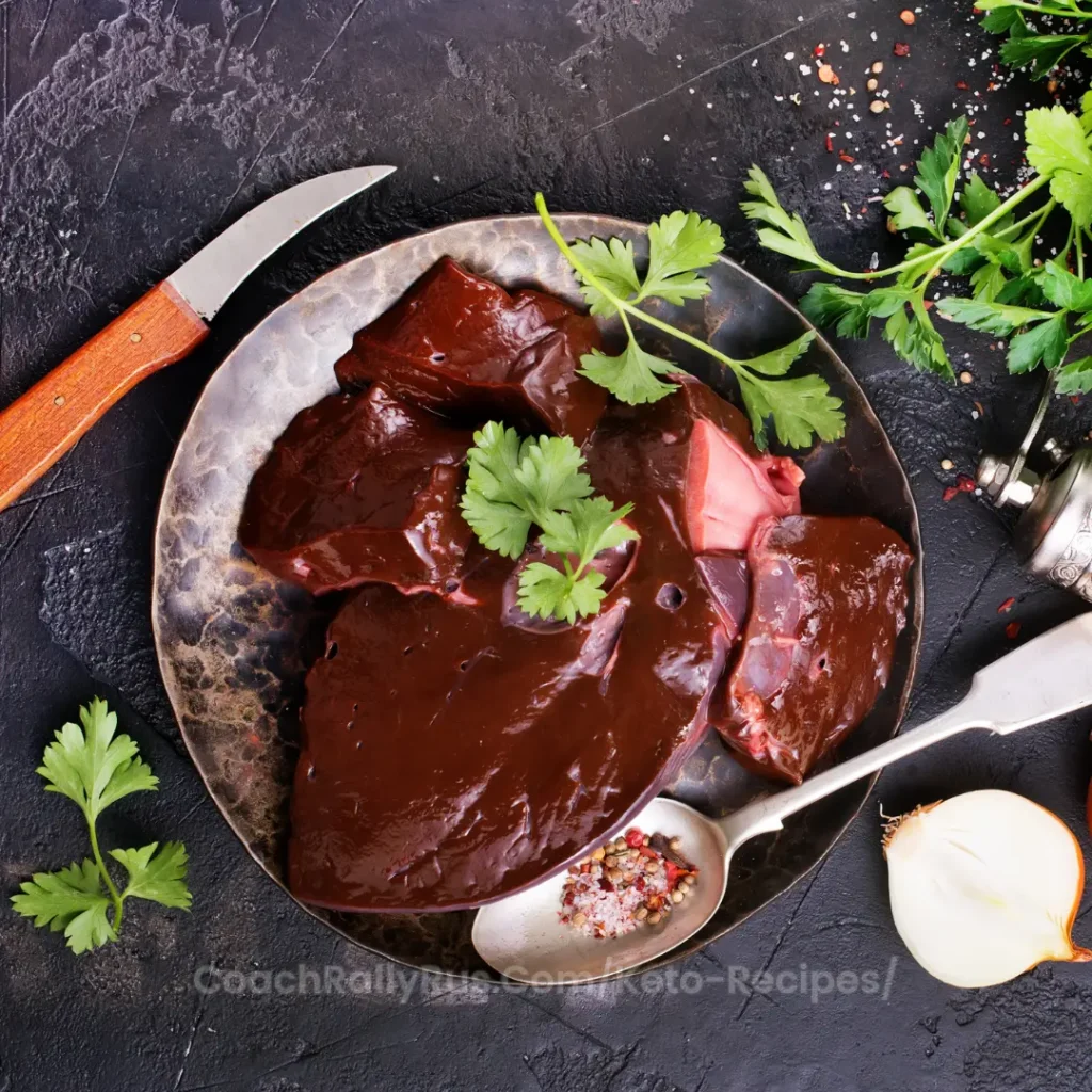A rustic plate of raw beef liver garnished with parsley on a dark background.