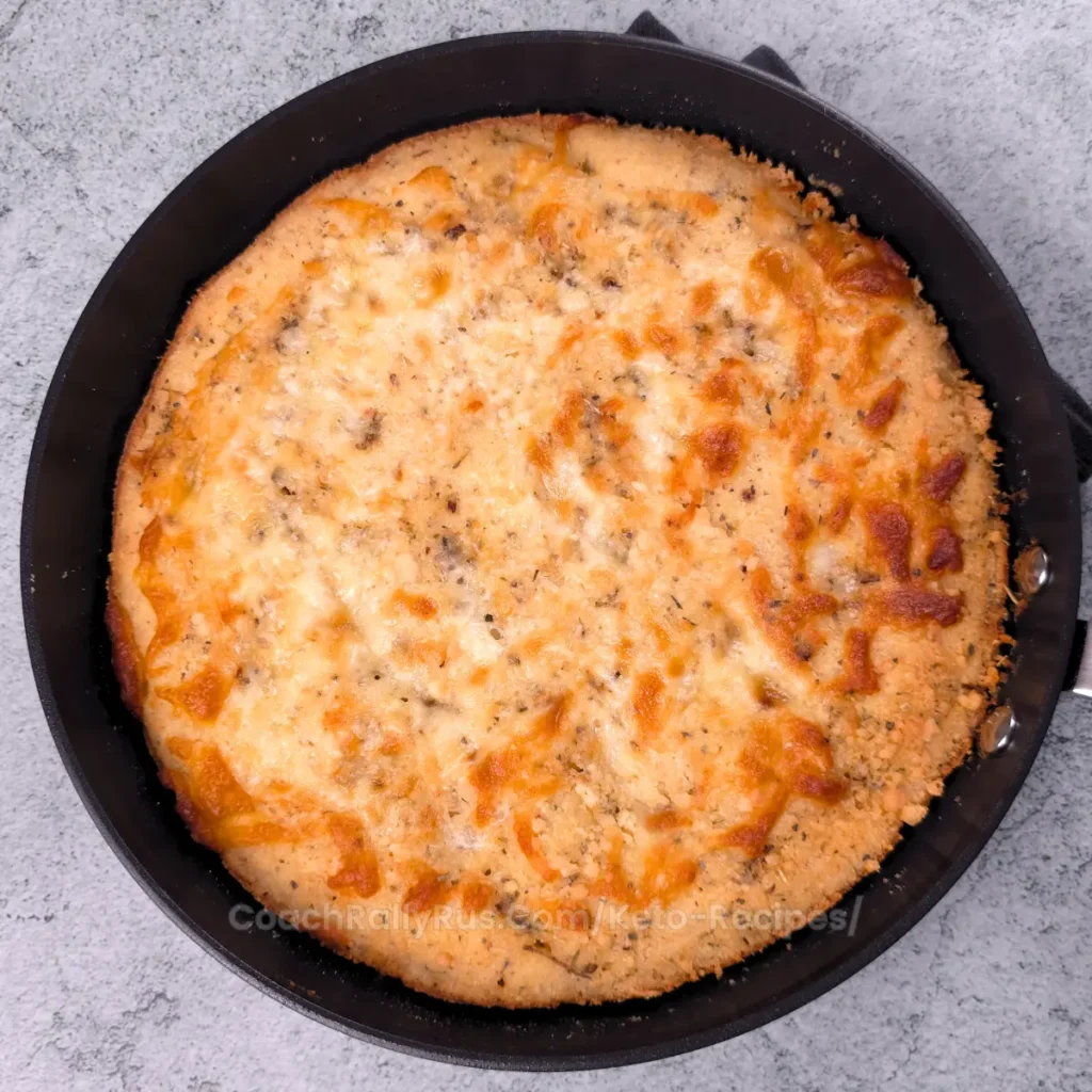 Golden-brown keto cottage cheese focaccia in a cast iron skillet.