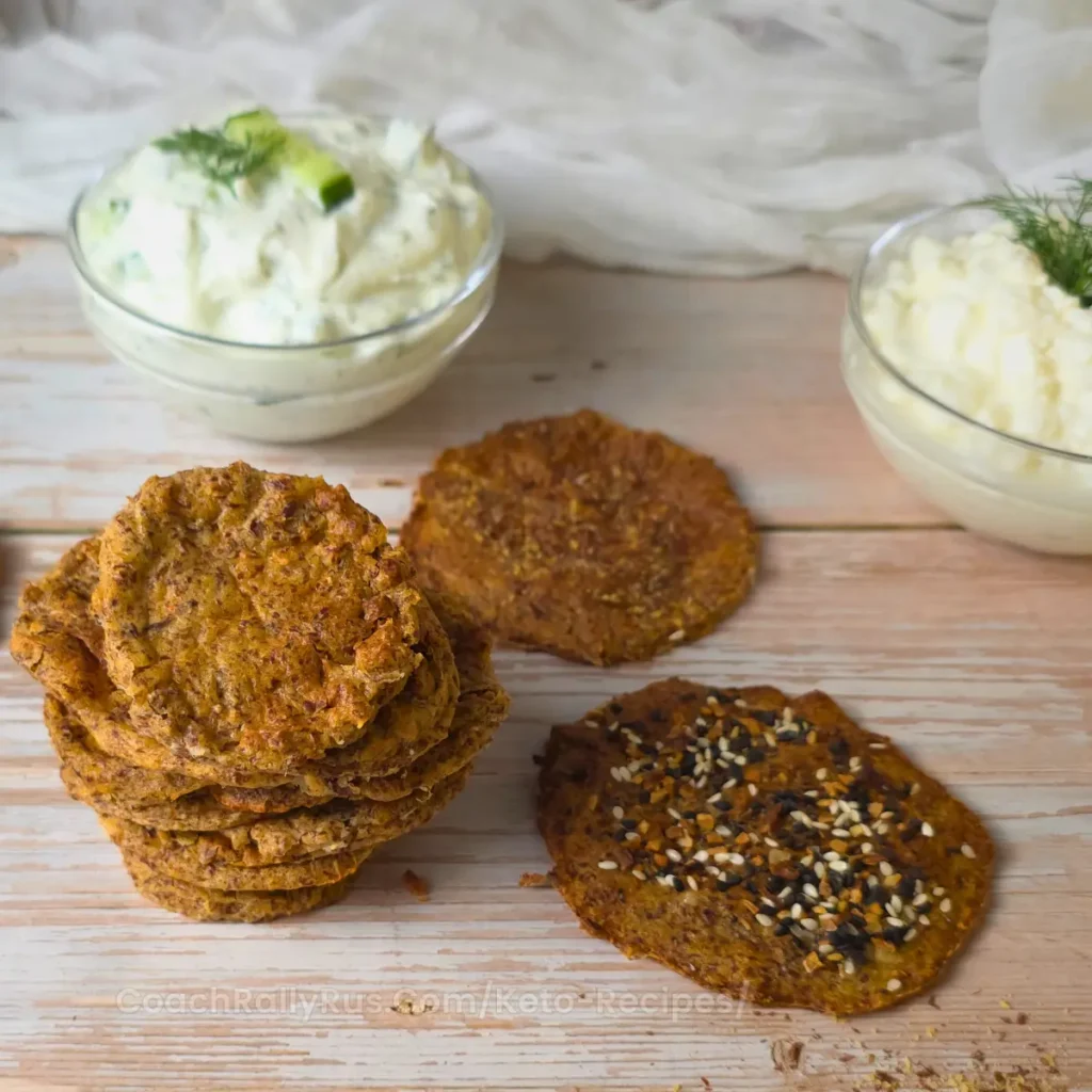 Close-up of keto flaxseed cottage cheese chips in a glass bowl with dips in the background.