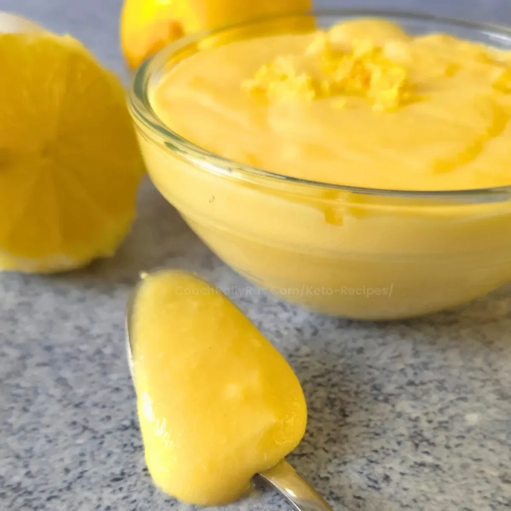 keto lemon curd in a glass bowl with fresh lemons and egg
