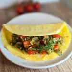 Mediterranean keto omelette with cauliflower rice, peppers, onions, and fresh dill on a white plate.
