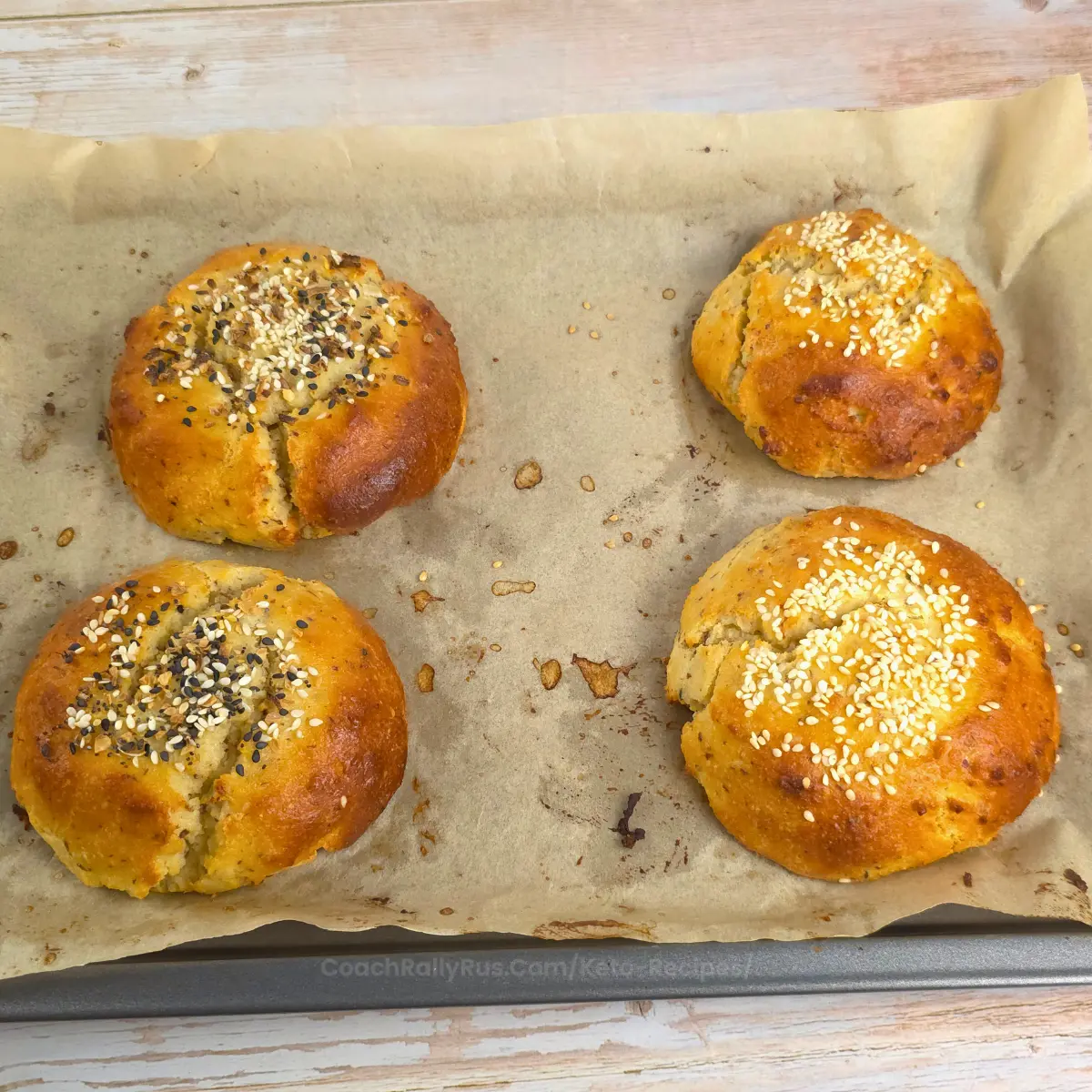 Freshly baked egg free cottage cheese keto burger buns on parchment paper.