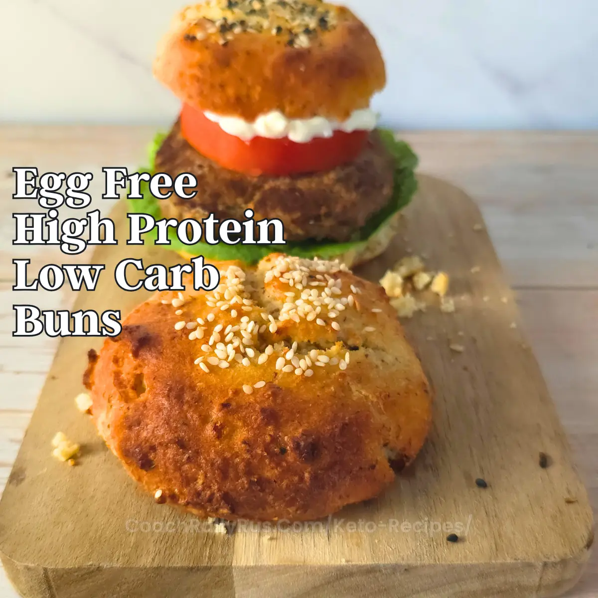 Egg free cottage cheese keto burger buns with sesame seeds on a wooden board.