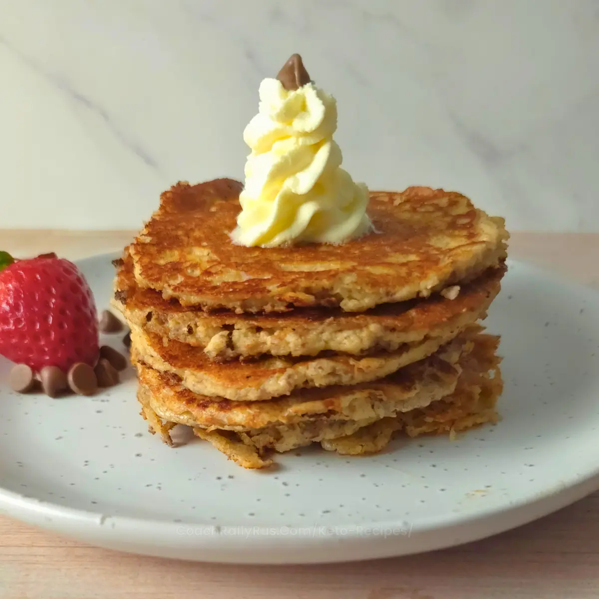 Stack of golden cottage cheese pancakes with whipped cream topping