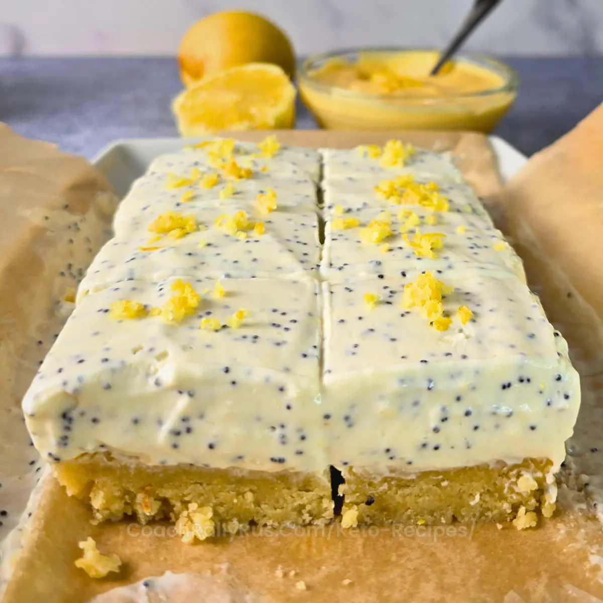 Sliced keto lemon cottage cheese bars on parchment paper with lemon curd in background.
