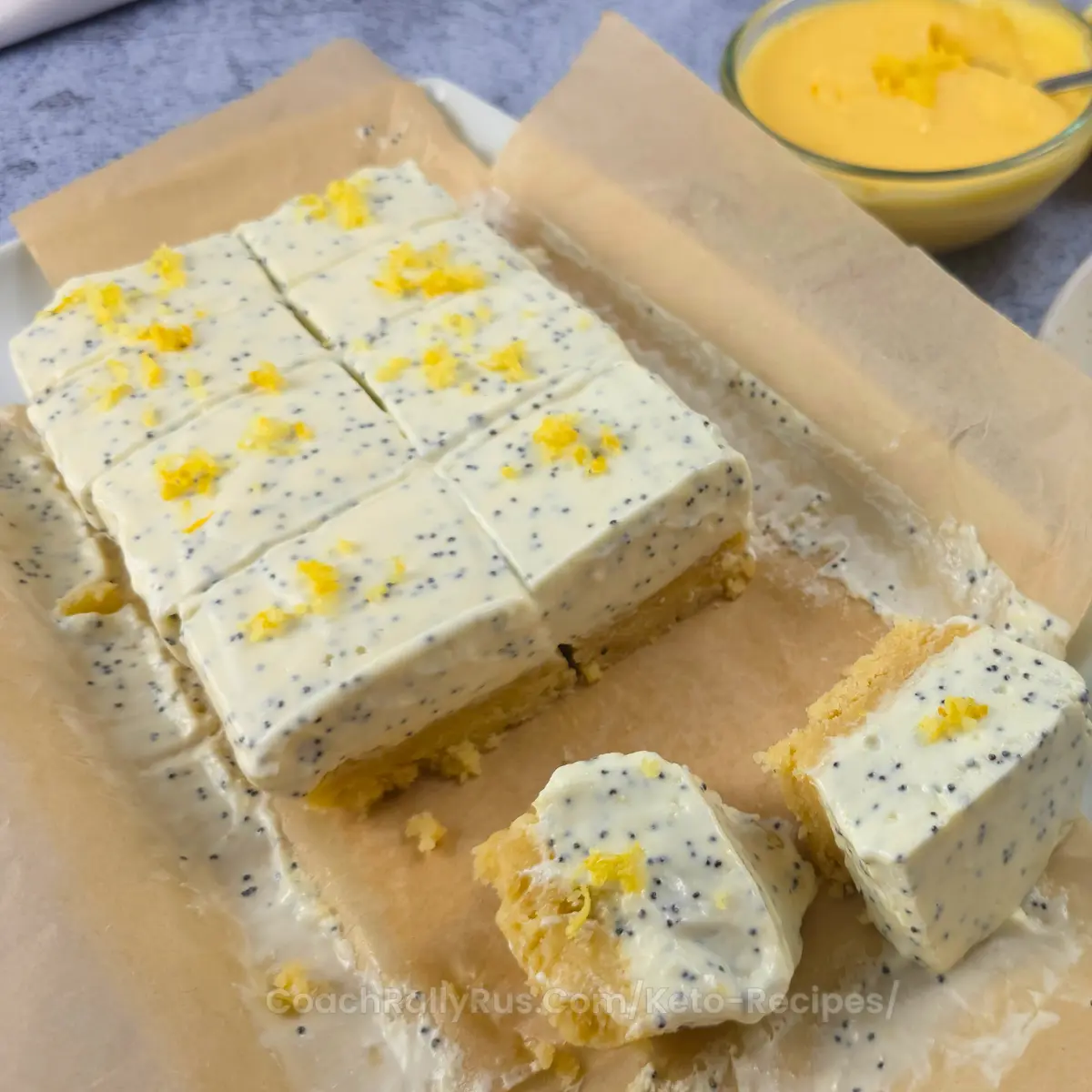 Whole batch of sliced keto lemon cottage cheese bars with lemon zest.