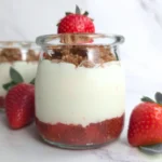 High protein keto strawberry cottage cheese parfait in a glass jar with strawberry jam and crumble