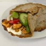 keto cottage cheese wrap filled with chicken, cucumber, tomato, and sauce