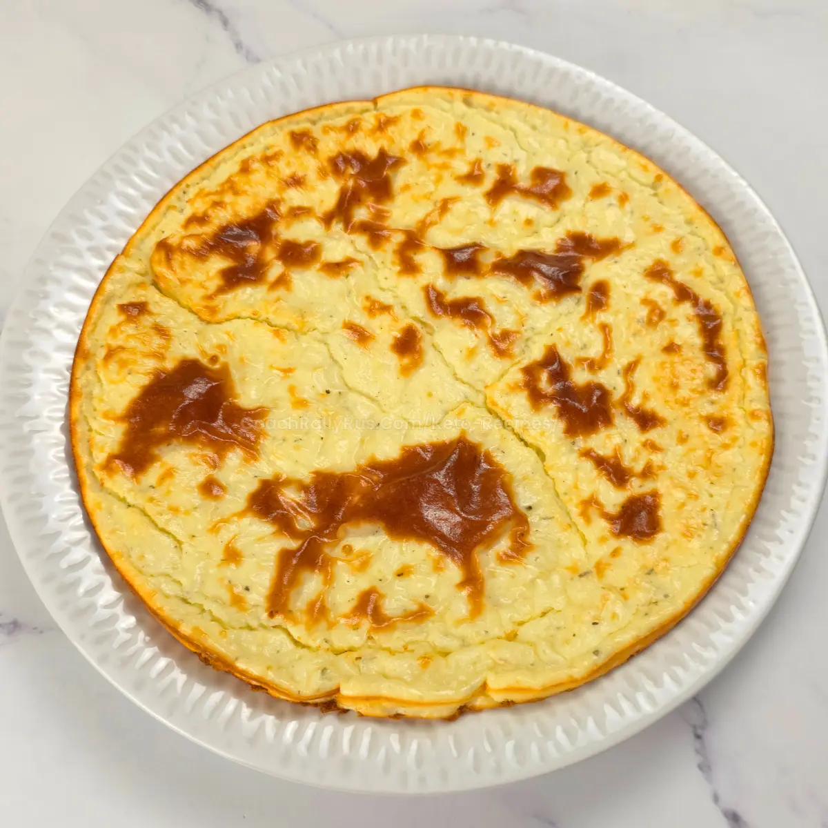 Full baked cottage cheese coconut flour pizza crust on a plate