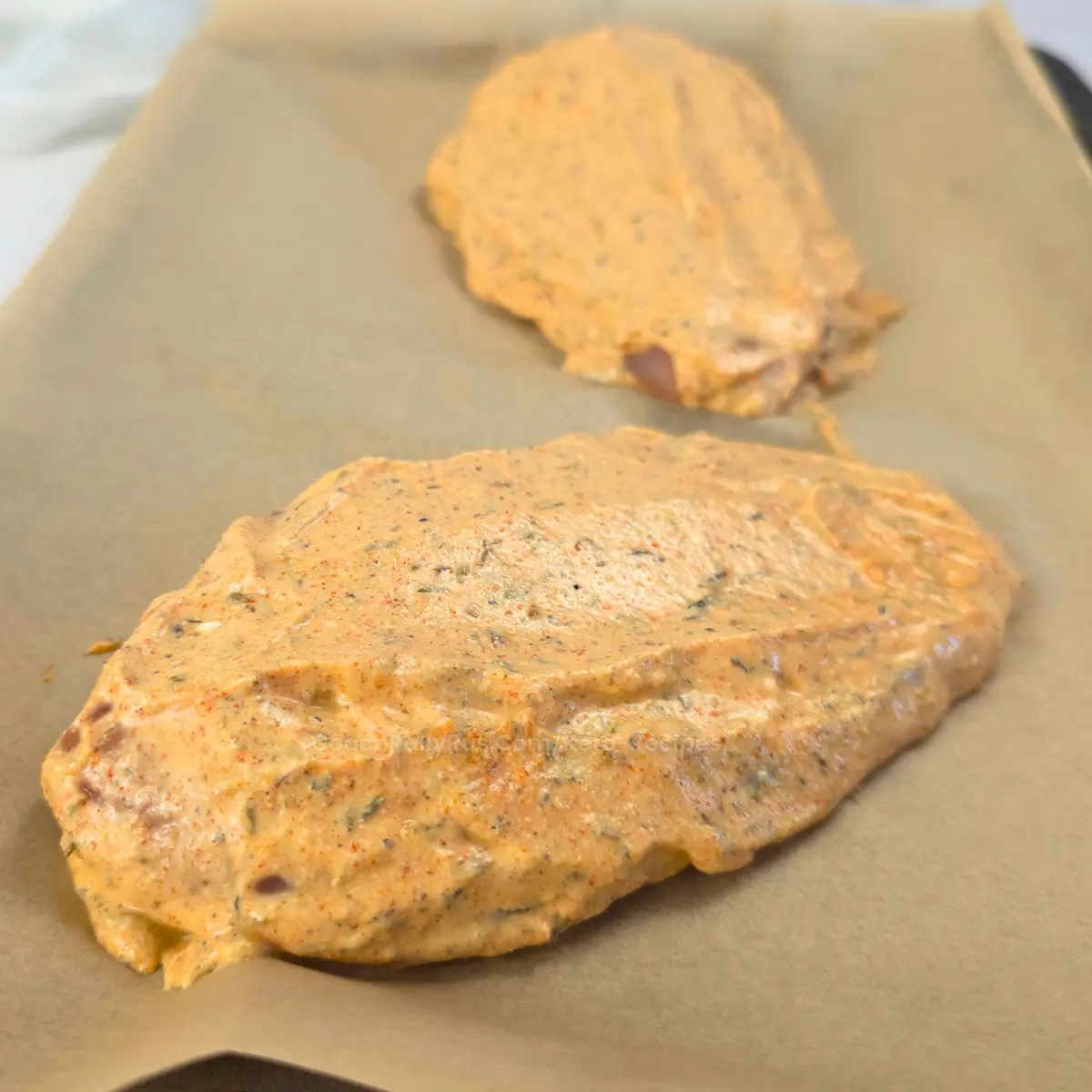 Chicken breast marinated in cottage cheese and gyro spices on parchment