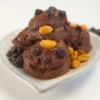 Chocolate peanut butter cookie dough made with cottage cheese, styled in playful scoops on a white dish, garnished with roasted peanuts and chocolate chips