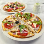 Sliced cottage cheese flatbread pizza with tzatziki and chicken gyros