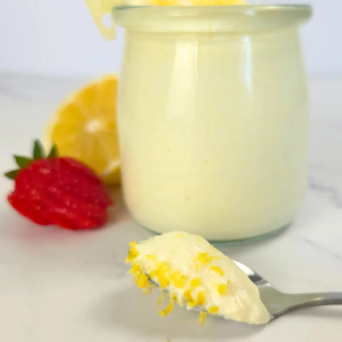 spoonful of whipped lemon cottage cheese fluff next to a glass jar