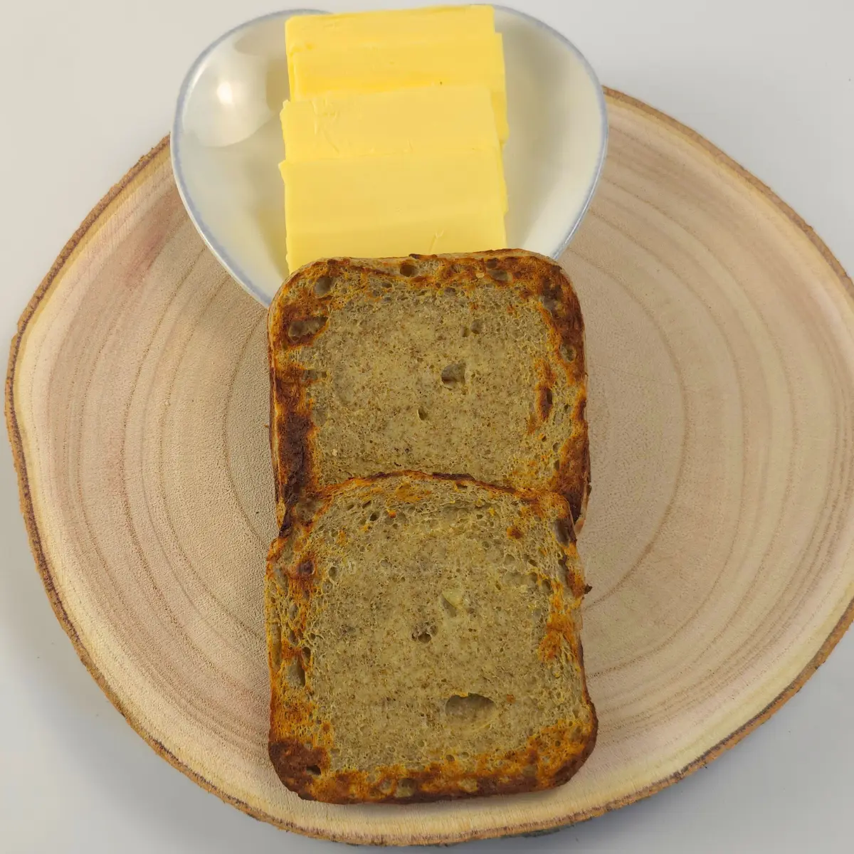 Toasted chia mug bread with sliced butter on plate