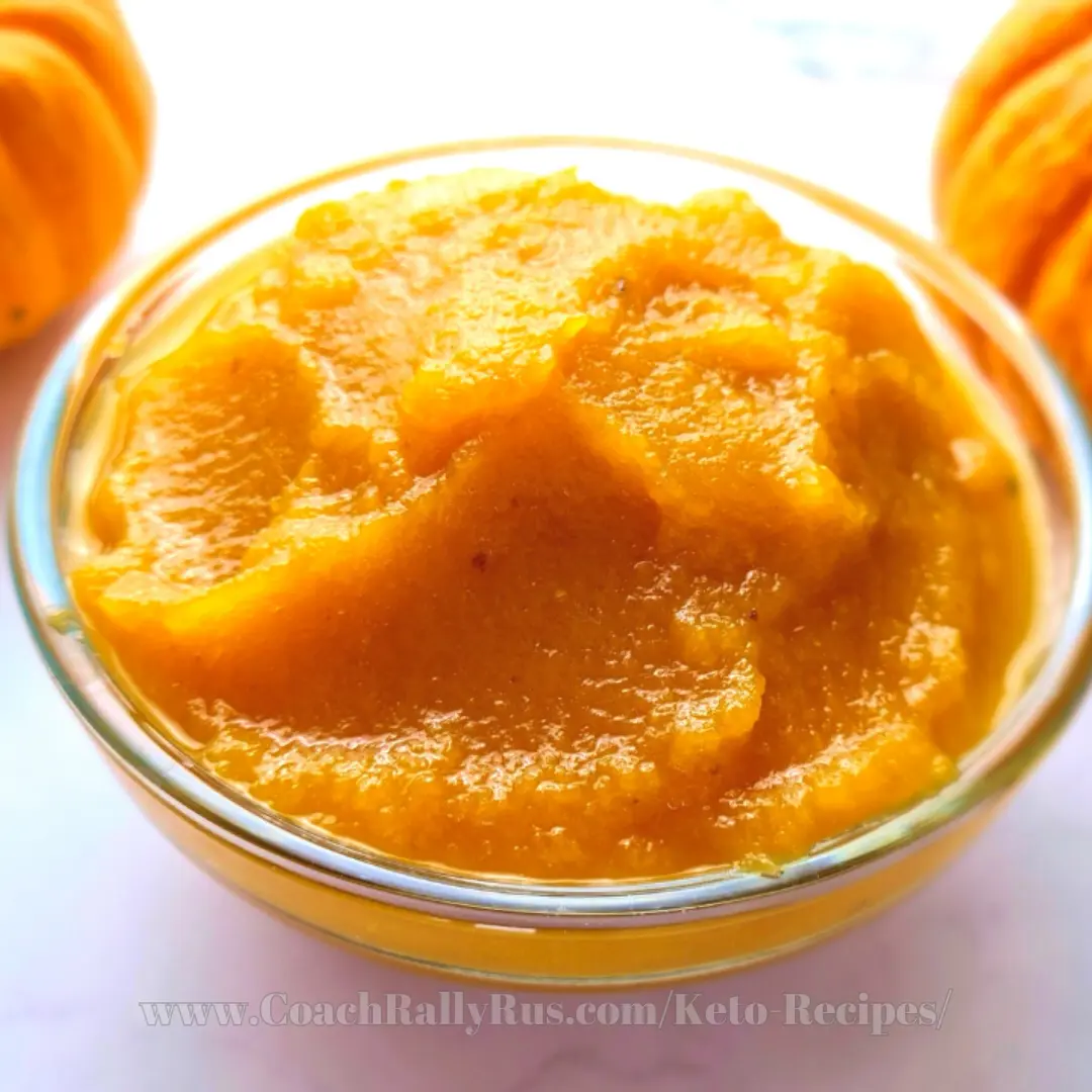 Bowl of smooth keto pumpkin puree with orange pumpkins