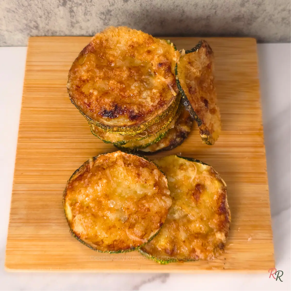 Top view of keto zucchini chips stacked and spread on a board