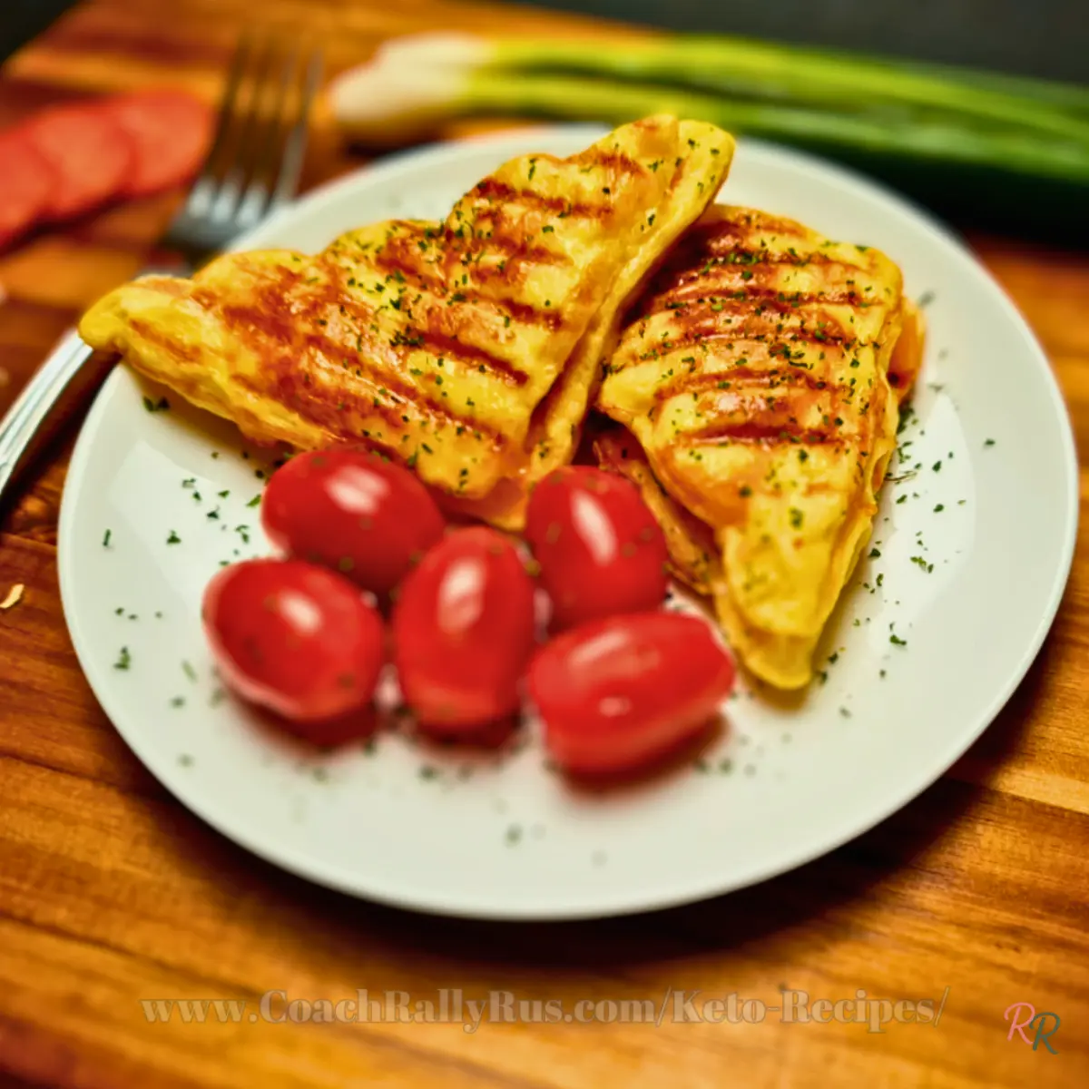 Crispy keto chaffle sandwich with grilled lines and fresh tomatoes on the side.