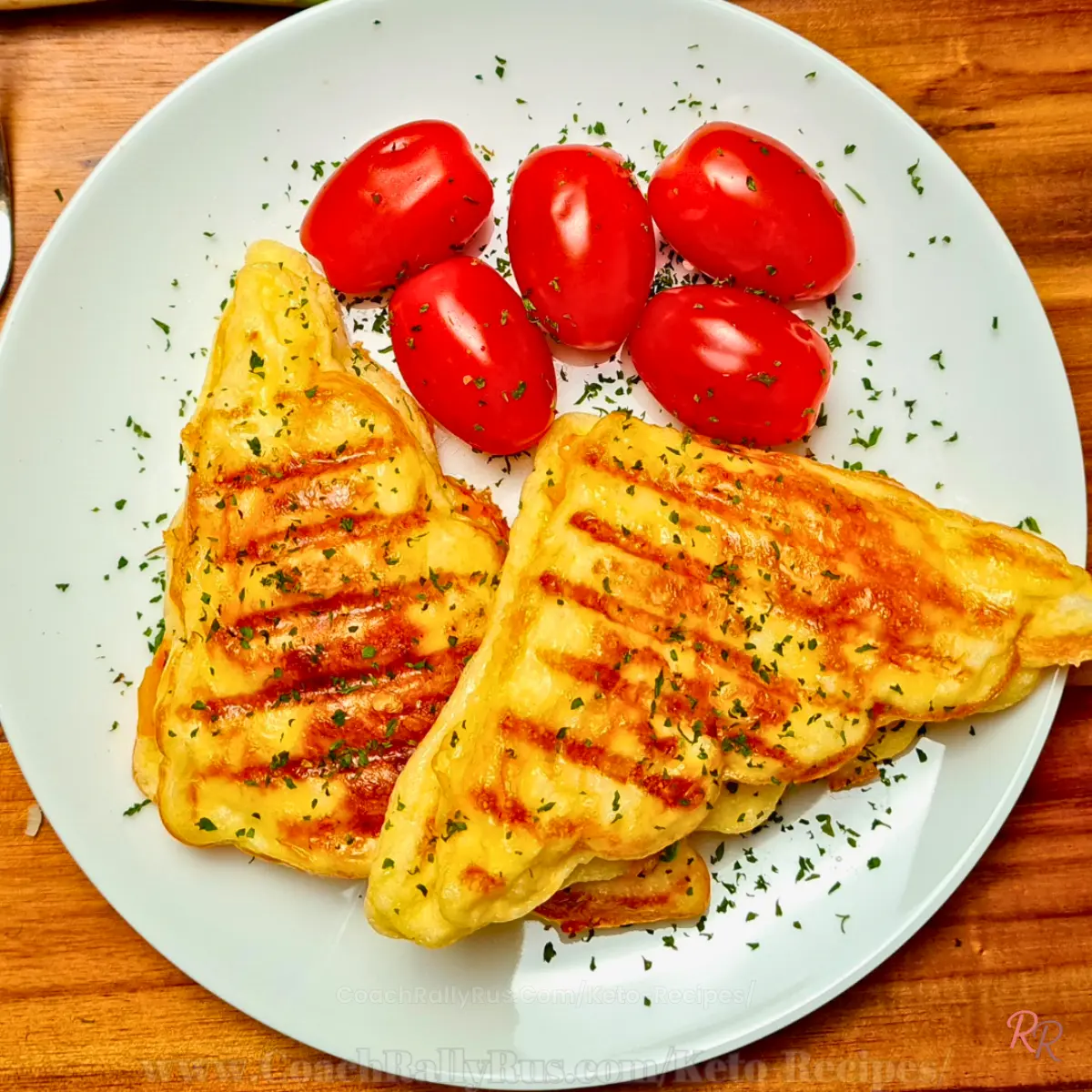 Overhead view of keto chaffwich sandwiches with golden grill marks and cherry tomatoes.