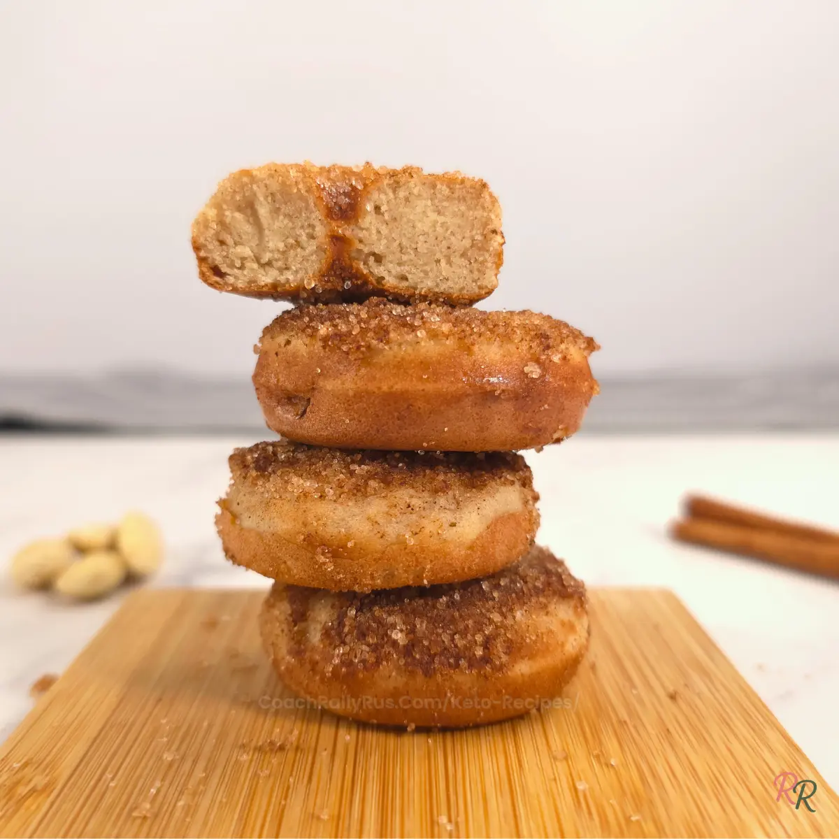 Stack of cinnamon sugar almond flour donuts on cutting board by Rally Rus.