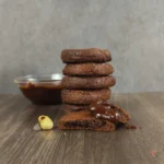 Stack of keto Nutella cookies with one broken cookie showing chocolate filling