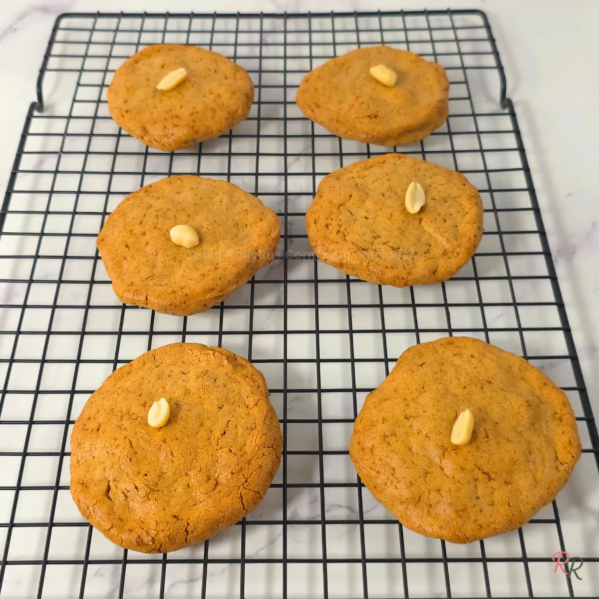 Keto Peanut Butter Cookies Cooling on Rack Freshly baked keto peanut butter cookies cooling on wire rack.