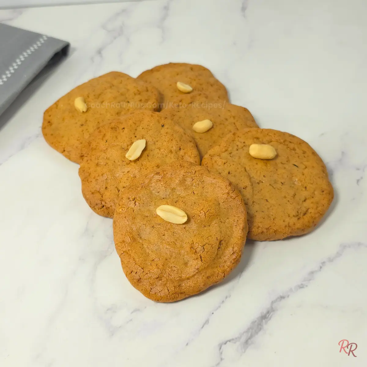 3 Ingredient Peanut Butter Cookies Sugar Free Freshly baked keto peanut butter cookies with peanuts on marble background.