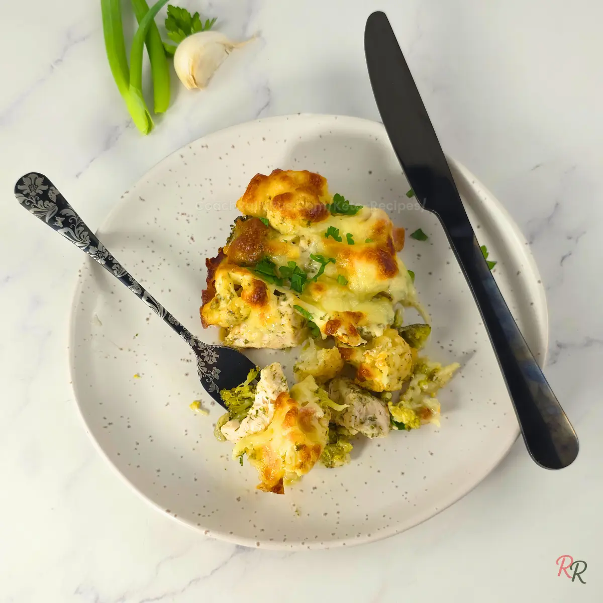 Low Carb Chicken Bacon Ranch Casserole Portion Serving of Keto chicken bacon ranch casserole on a white plate with golden cheese topping.
