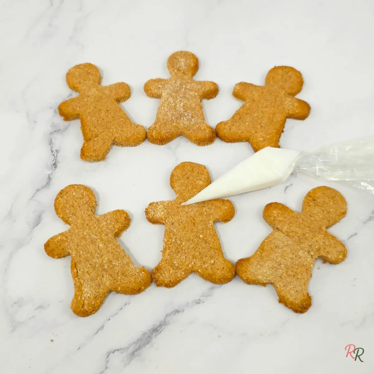 Plain keto gingerbread men cookies ready to be iced with white piping