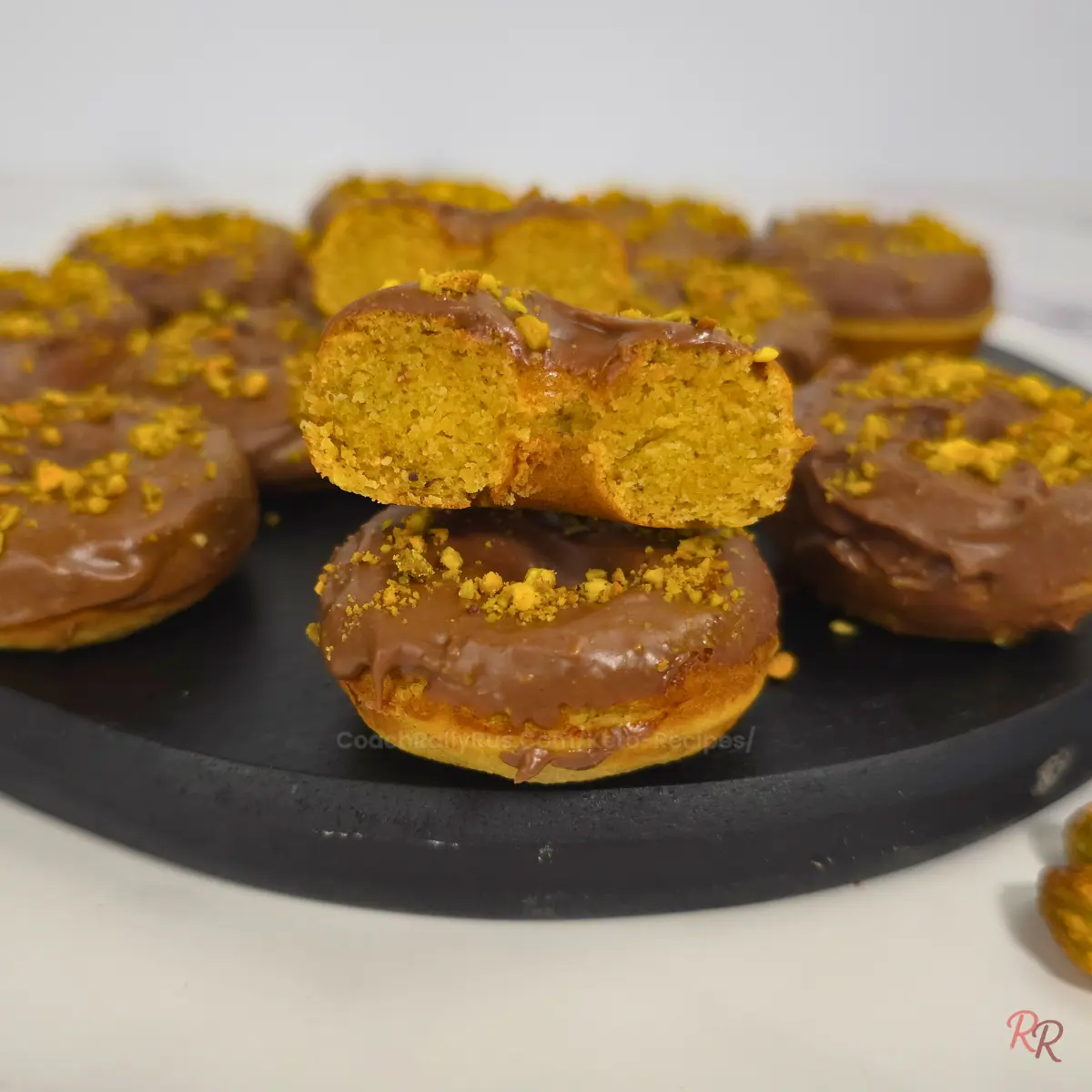 Keto pistachio almond flour donuts stacked on top of each other with visible cross-section.