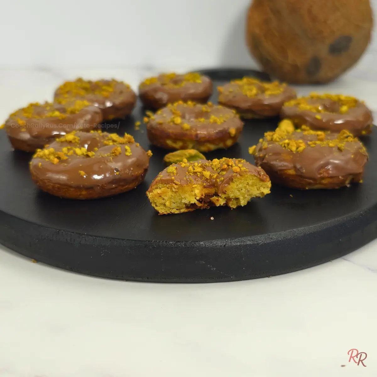 Side view of keto pistachio donuts showing moist crumb and chocolate glaze