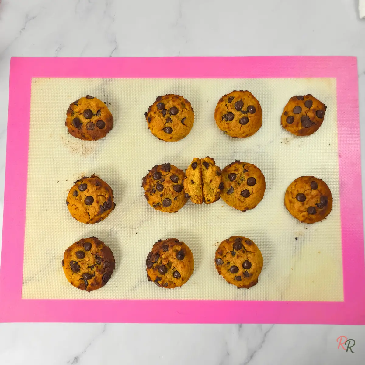 Freshly baked keto cottage cheese pumpkin cookies with chocolate chips cooling on a baking mat