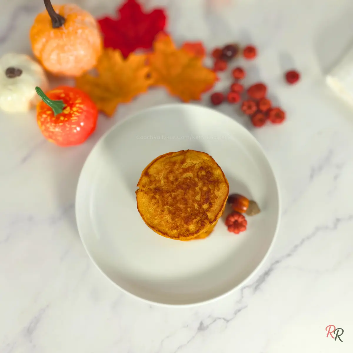 Stack of fluffy golden pumpkin cottage cheese pancakes on a white plate with fall decorations, by Rally Rus