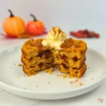 Keto pumpkin waffles cut open with whipped cream on top