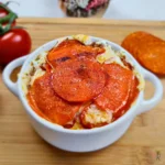 Crustless cottage cheese pizza bowl with melted cheese and pepperoni slices.